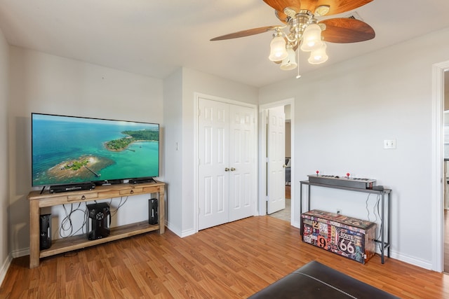 living room featuring wood-type flooring and ceiling fan