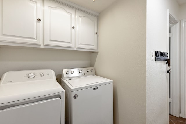 laundry area with washing machine and clothes dryer and cabinets