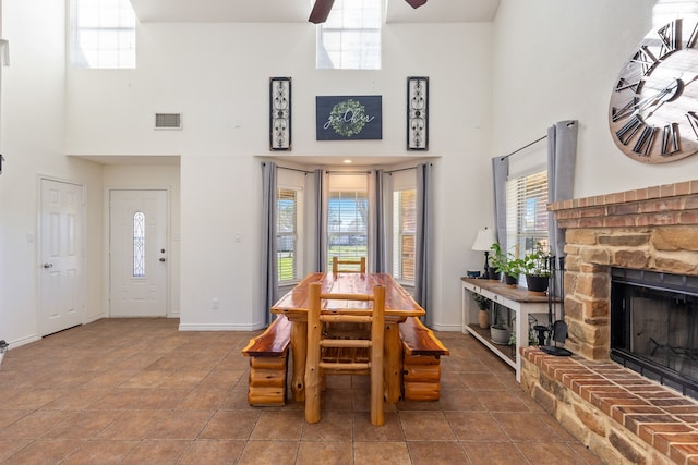 tiled dining space with a high ceiling, plenty of natural light, and ceiling fan