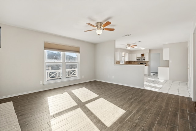 unfurnished living room featuring dark hardwood / wood-style floors and ceiling fan