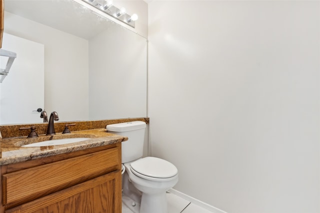 bathroom with tile patterned flooring, vanity, and toilet