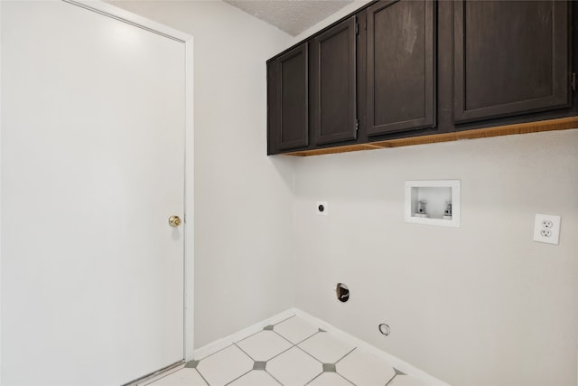 clothes washing area featuring hookup for an electric dryer, hookup for a washing machine, cabinets, a textured ceiling, and hookup for a gas dryer