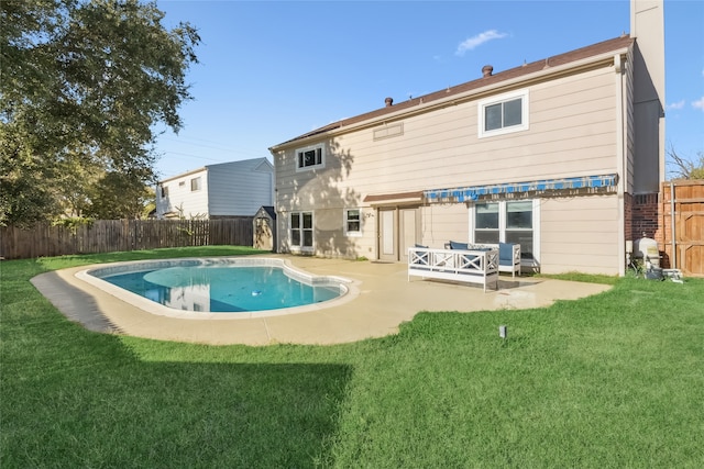 back of house with a lawn, a patio area, and a fenced in pool