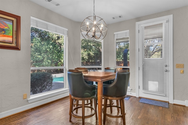 dining room with a chandelier, a healthy amount of sunlight, and wood-type flooring