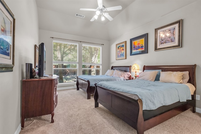 bedroom featuring ceiling fan, light colored carpet, lofted ceiling, and ensuite bath