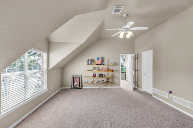 carpeted home theater room with ceiling fan, french doors, and lofted ceiling