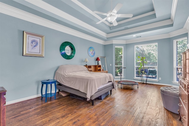 bedroom featuring ceiling fan, a raised ceiling, ornamental molding, and dark wood-type flooring