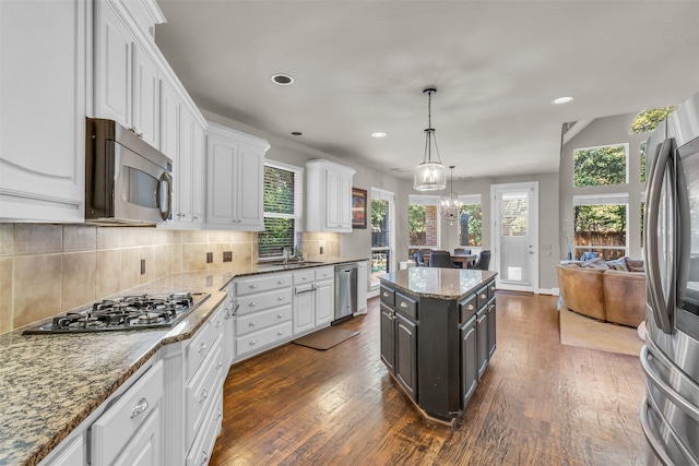 kitchen featuring white cabinets, pendant lighting, dark wood-type flooring, and appliances with stainless steel finishes