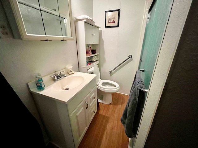 bathroom featuring wood-type flooring, vanity, and toilet