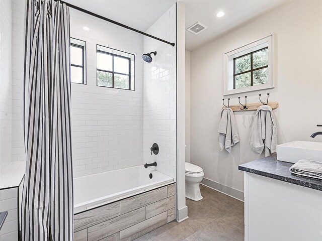 full bathroom featuring a wealth of natural light, tile patterned flooring, vanity, and shower / tub combo