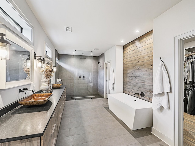 bathroom with tile patterned flooring, vanity, and plus walk in shower