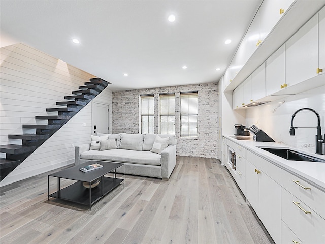 living room with sink and light hardwood / wood-style flooring