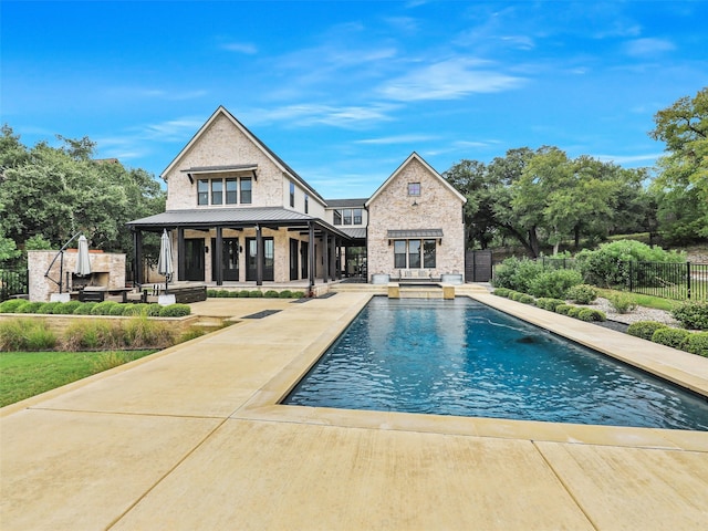 rear view of property featuring a fenced in pool and a patio