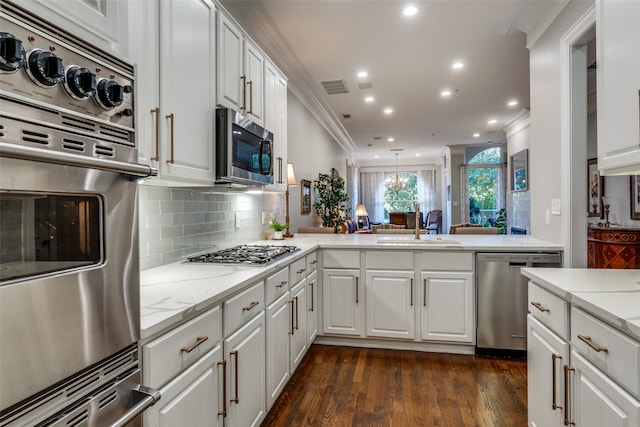 kitchen with sink, dark hardwood / wood-style flooring, crown molding, white cabinets, and appliances with stainless steel finishes