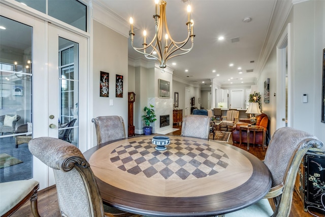 dining space featuring crown molding, a chandelier, and hardwood / wood-style flooring