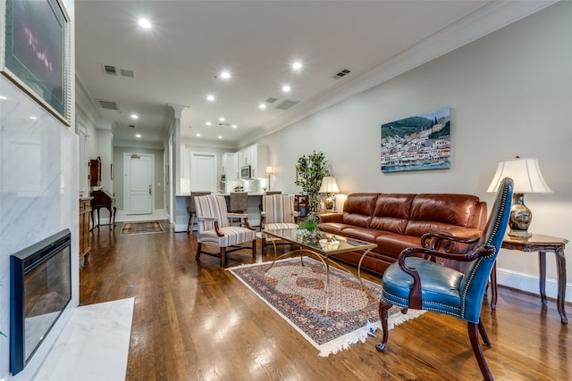 living room with dark hardwood / wood-style floors, ornamental molding, a high end fireplace, and heating unit