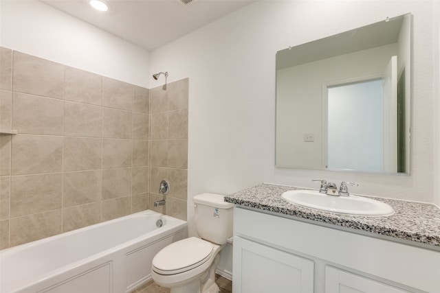 full bathroom featuring vanity, tiled shower / bath combo, and toilet