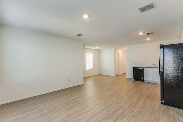 unfurnished living room featuring light wood-type flooring and sink