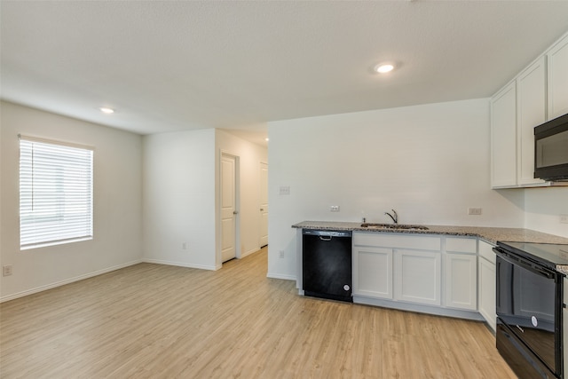 kitchen with light stone counters, light hardwood / wood-style floors, white cabinetry, and black appliances