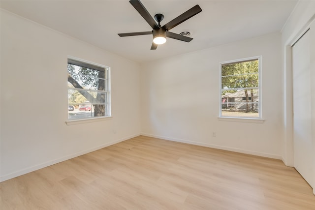 unfurnished room featuring ceiling fan, plenty of natural light, and light wood-type flooring