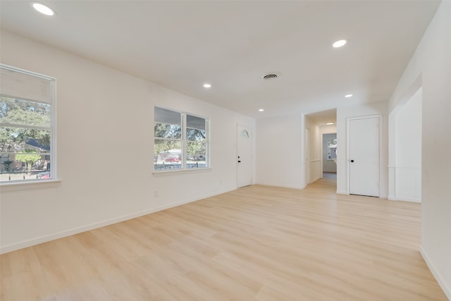 spare room featuring light hardwood / wood-style flooring and a healthy amount of sunlight