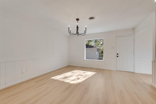 unfurnished dining area with light hardwood / wood-style flooring and an inviting chandelier