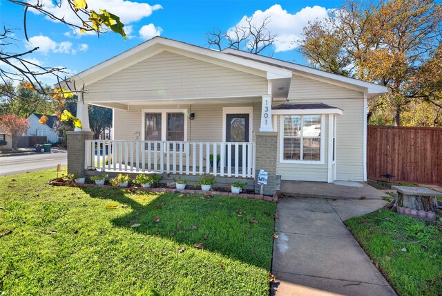 view of front of home featuring covered porch and a front lawn