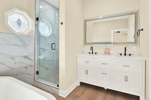 bathroom featuring vanity, wood-type flooring, and plus walk in shower