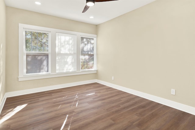 empty room featuring ceiling fan, hardwood / wood-style floors, and a healthy amount of sunlight