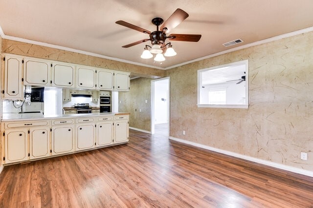 kitchen featuring light hardwood / wood-style floors, stainless steel appliances, and crown molding