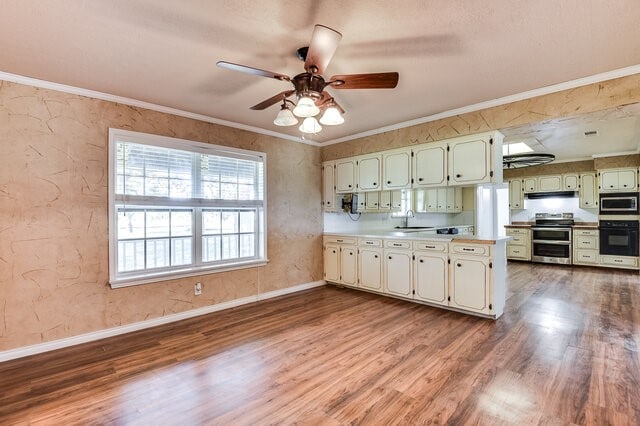 kitchen featuring crown molding, sink, stainless steel appliances, and light hardwood / wood-style flooring