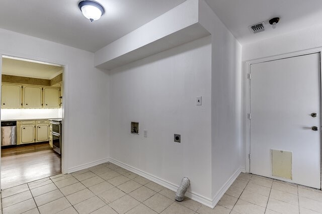 clothes washing area featuring washer hookup, light tile patterned floors, and electric dryer hookup