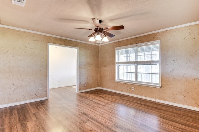 spare room featuring hardwood / wood-style flooring, ceiling fan, and ornamental molding