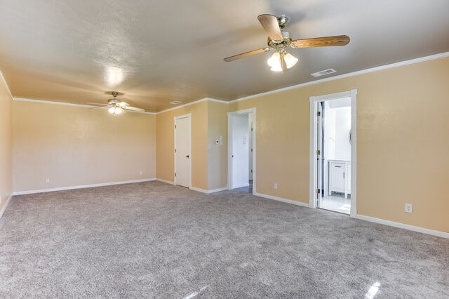 spare room featuring ceiling fan, light colored carpet, and ornamental molding