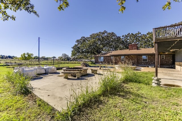 view of yard with a fire pit, a patio area, and a deck