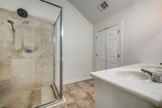 bathroom featuring tile patterned floors, a shower with shower door, lofted ceiling, and vanity