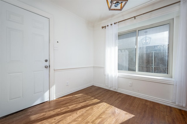 unfurnished dining area with crown molding and hardwood / wood-style floors