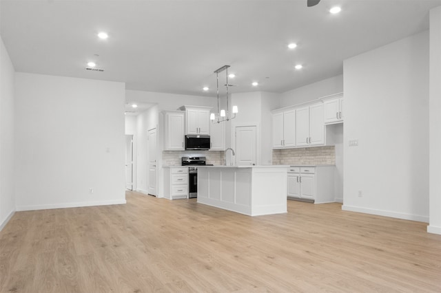 kitchen featuring decorative backsplash, white cabinetry, stainless steel appliances, and light countertops