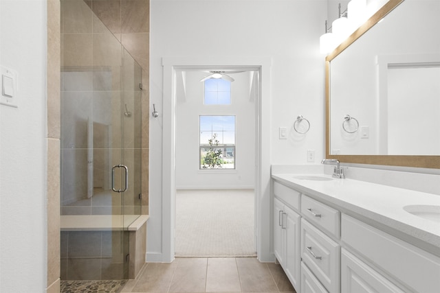 full bath with double vanity, a shower stall, tile patterned flooring, and a sink