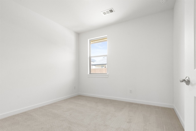 empty room with light colored carpet, baseboards, and visible vents