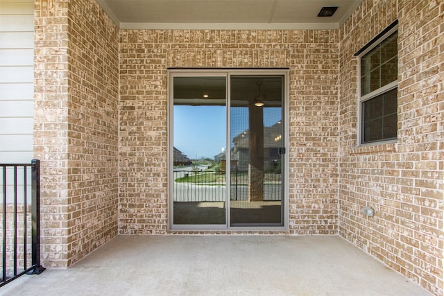 exterior space featuring brick siding and a patio