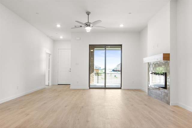 unfurnished living room featuring recessed lighting, a glass covered fireplace, light wood-style flooring, and a ceiling fan