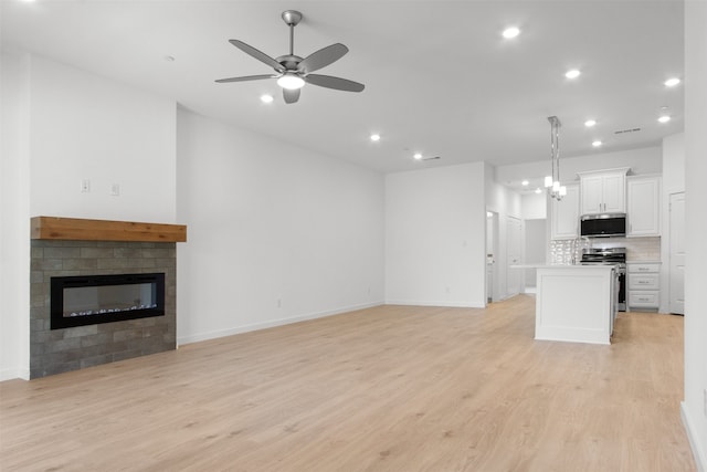 unfurnished living room featuring ceiling fan, light wood-type flooring, and recessed lighting