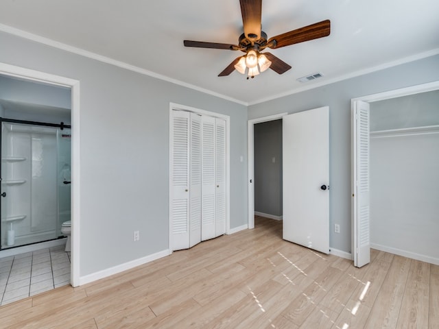 unfurnished bedroom featuring connected bathroom, multiple closets, and light wood-type flooring