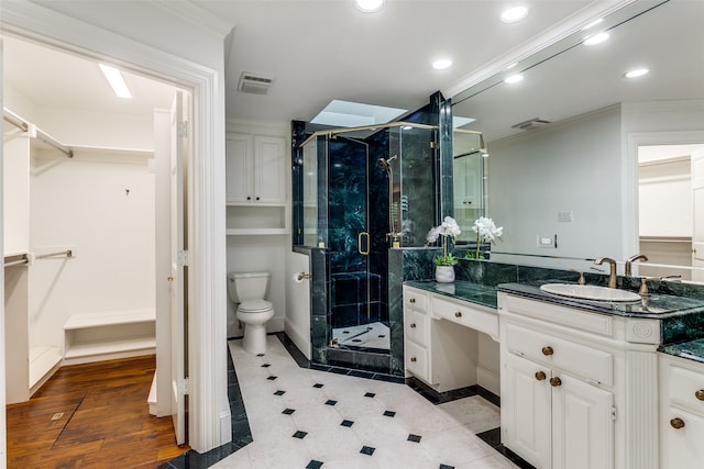 bathroom with walk in shower, vanity, crown molding, hardwood / wood-style floors, and toilet