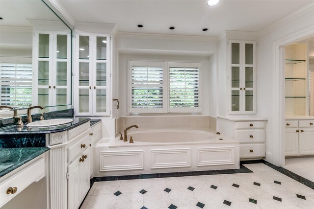 bathroom featuring ornamental molding, vanity, and a tub