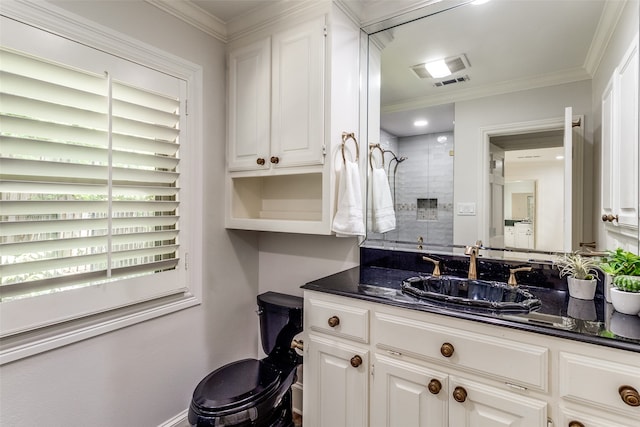 bathroom with crown molding, vanity, and tiled shower