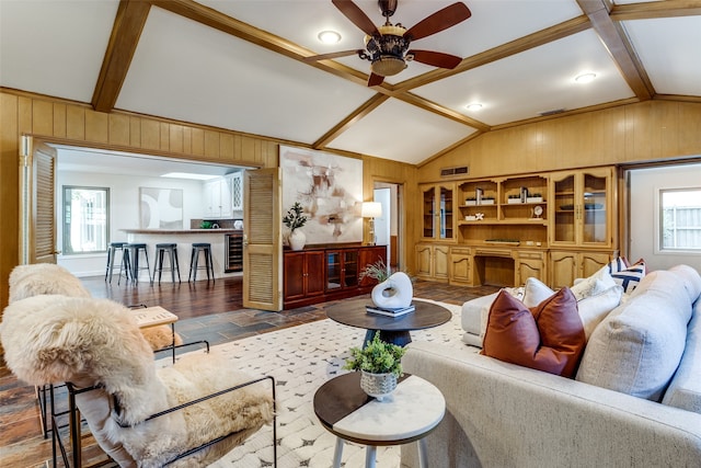 living room featuring vaulted ceiling with beams, ceiling fan, dark hardwood / wood-style flooring, and wooden walls