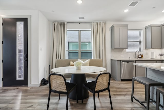 dining space with light hardwood / wood-style floors and sink