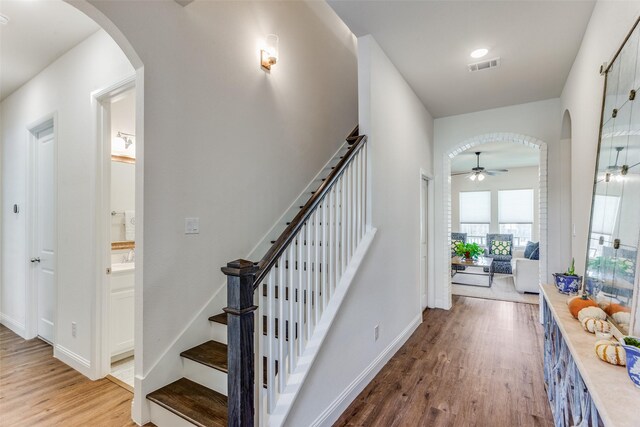 stairs featuring ceiling fan and wood-type flooring